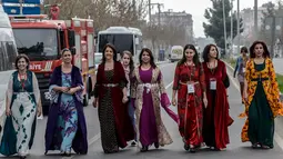 Anggota PM perempuan Partai Demokrasi Rakyat (HDP) dan Pemimpin Wanita HDP Pervin Buldan (tiga kiri) ikut memperingati Women's Day atau Hari Perempuan Internasional di Diyarbakir, Turki, Kamis (8/3). (ILYAS AKENGIN/AFP)
