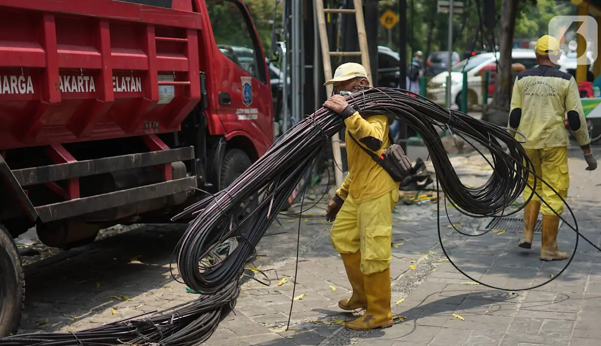 Petugas Bina Marga usai memotong kabel optik di sepanjang jalan kawasan Kemang, Jakarta, Kamis (24/10/2019). Pemotongan kabel optik tersebut untuk menertibkan instalasi kabel yang semrawut serta mengganggu ketertiban umum di kawasan Kemang. (Liputan6.com/Immanuel Antonius)
