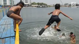 Anak-anak berenang dan bermain air dekat tanggul laut Muara Baru di Penjaringan, Jakarta Utara, Minggu (1/9/2019). Anak-anak memanfaatkan sisi tanggul laut raksasa (giant sea wall) sebagai   tempat  bermain alternatif. (merdeka.com/Arie Basuki)