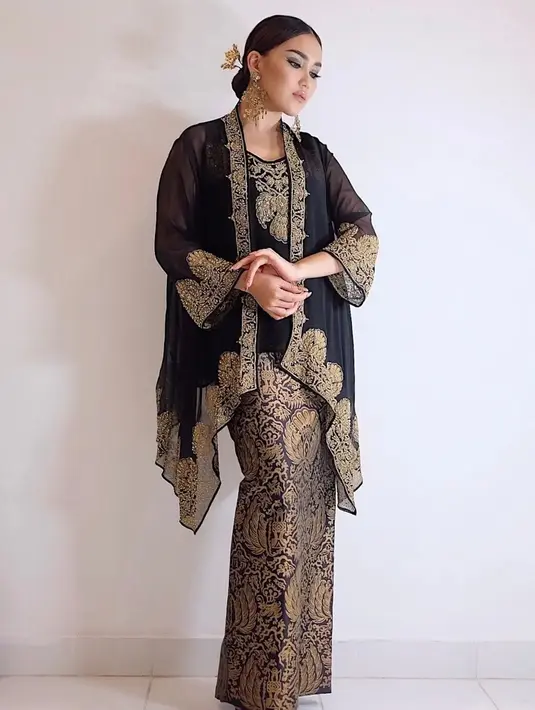 Pesona Ayu Ting Ting memakai batik berwarna hitam dengan detail motif emas ini membuatnya banjir pujian. Dirinya juga tampil dengan rambut yang disanggul kecil serta aksesoris. (Liputan6.com/IG/@ayutingting92)