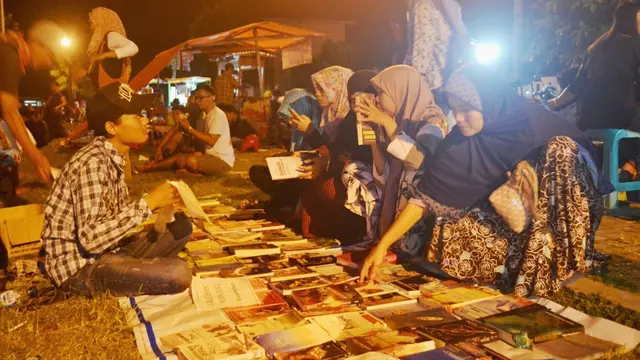 Sejumlah orang membaca buku di lapak perpustakaan gratis Komunitas Gerakan Membaca Buku Sidareja (Gembus) di Alun-alun Sidareja, Cilacap. (Foto: Liputan6.com / Muhamad Ridlo)