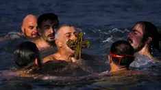 Umat Ortodoks Yunani mencium kayu salib setelah diambil di Tanduk Emas saat perayaan Epiphany di Istanbul, Turki, 6 Januari 2022. Epiphany adalah sebuah hari raya keagamaan dalam sejumlah denominasi gereja Kristen pada tanggal 6 Januari. (AP Photo/Francisco Seco)