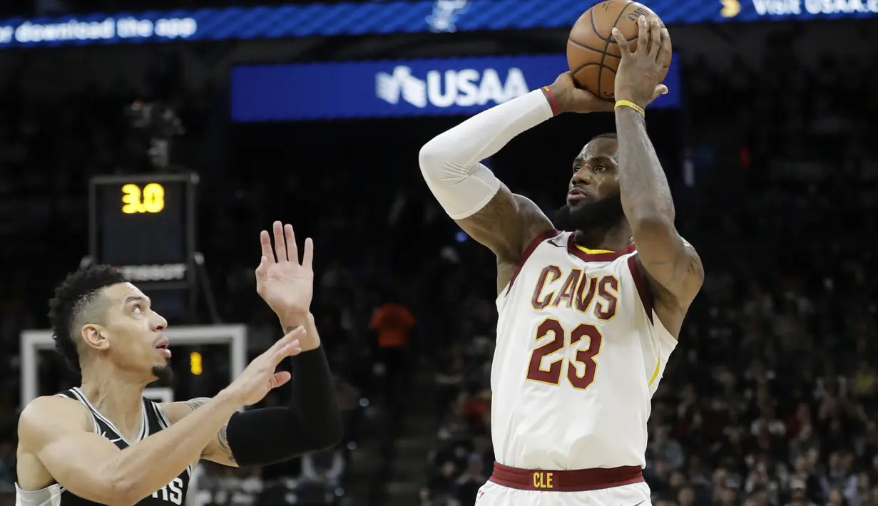 Aksi pemain Cleveland Cavaliers, LeBron James (23) melakukan tembakan melewati pemain Spurs, Danny Green (kiri) pada lanjutan NBA di basketball game di AT&T Center, San Antonio, (23/1/2018). Spurs menang 114—102. (AP/Eric Gay)