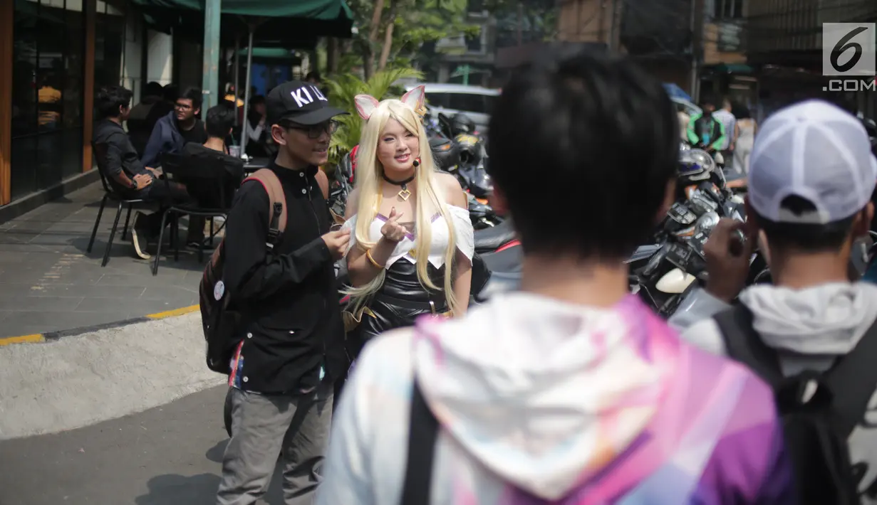Pengunjung berfoto bersama seorang wanita dengan kostum unik saat gelaran Festival Little Tokyo di kawasan Blok M, Jakarta, Minggu (23/6/2019). Festival Little Tokyo menghadirkan berbagai jenis kuliner dan kebudayaan Jepang. (Liputan6.com/Faizal Fanani)