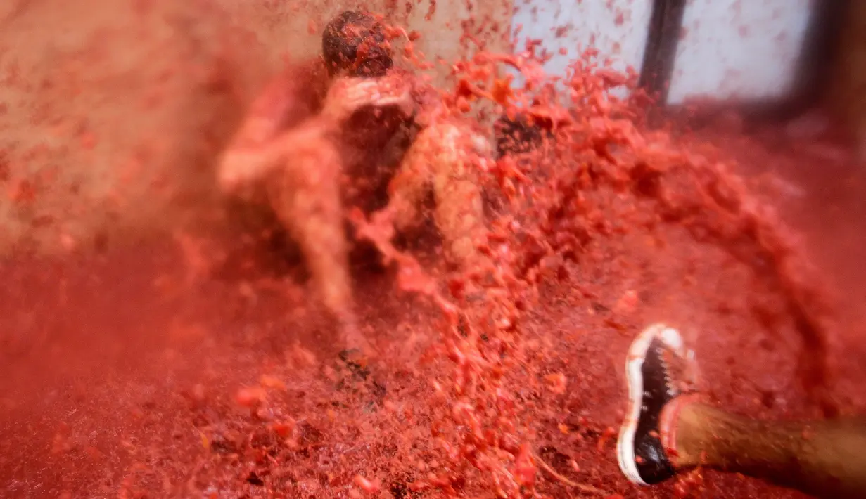 Seorang peserta mandi tomat saat mengikuti Festival Tomatina (perang tomat) di Bunol, Valencia, Spanyol, Rabu (31/8). Sekitar 170 ton atau 175 ribu kilogram tomat matang digunakan untuk acara Perang Tomat tersebut. (REUTERS / Heino Kalis)