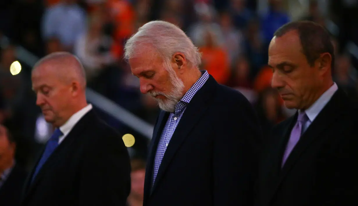 Pelatih San Antonio Spurs, Gregg Popovich (tengah) mengheningkan cipta untuk mengenang  pembawa  acara Craig Sager sebelum melawan Phoenix Suns pada laga NBA di Talking Stick Resort Arena; (15/12/2016). (Reuters/Mark J. Rebilas-USA TODAY Sports)