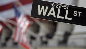 Dalam file foto 11 Mei 2007 ini, tanda Wall Street dipasang di dekat fasad terbungkus bendera dari Bursa Efek New York. (Richard Drew/AP Photo)