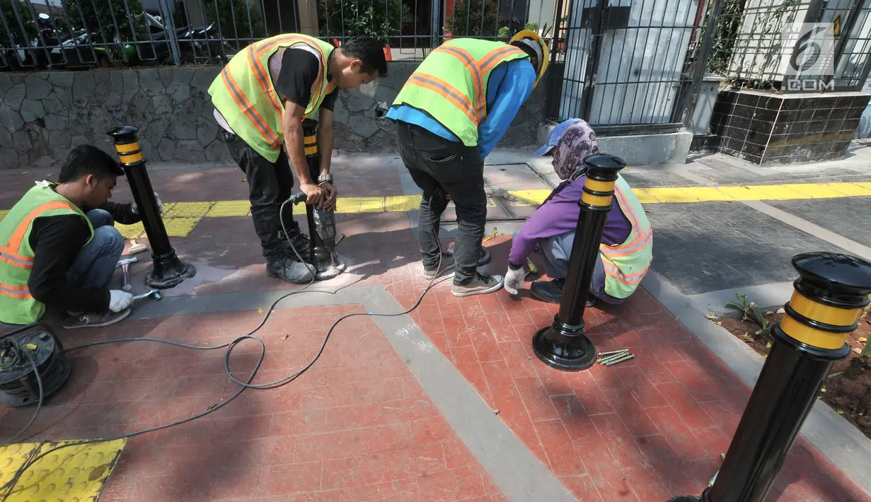 Pekerja memasang Bolar atau tiang pembatas pedestrian di kawasan Tugu Tani, Jakarta, Minggu (9/9). Pemasangan Bolar bertujuan menjaga keindahan jalur pedestrian dan mencegah penyalahgunaan fungsi.(merdeka.com/ Iqbal S. Nugroho)