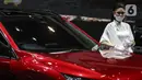 Sales Promotion Girl berdiri dekat mobil yang dipamerkan di Indonesia International Motor Show (IIMS) Hybrid 2021, JiExpo Kemayoran, Jakarta, Kamis (16/4/2021). Pameran otomotif IIMS Hybrid 2021 berlangsung pada 15-25 April. (Liputan6.com/Johan Tallo)
