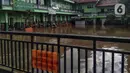 Banjir menggenangi sekolah di Kebalen, Jakarta, Minggu (21/2/2021). Banjir yang terjadi kemarin karena curah hujan yang tinggi meninggalkan sampah di rumah warga. (Liputan6.com/Johan Tallo)