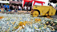 Petugas mengoperasikan Alat Berat untuk menghancurkan botol minuman keras (miras) di Mapolres Jakarta Selatan, Rabu (10/6/2015). Pemusnahan 8.000 botol miras untuk menekan peredaran miras khususnya menjelang bulan Ramadan. (Liputan6.com/Yoppy Renato)