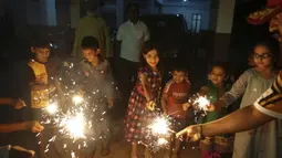 Anak-anak Muslim menyalakan petasan untuk merayakan Diwali, festival lampu, di Hyderabad, India, Senin (24/10/2022). Orang India di seluruh negeri merayakan Diwali, festival Hindu yang melambangkan kemenangan cahaya atas kegelapan. (AP Photo/Mahesh Kumar A.)