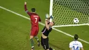 Pemain Portugal, Cristiano Ronaldo (kiri), mencoba menaklukkan kiper Islandia, Hannes Thor Halldorsson, pada laga Grup F Piala Eropa 2016 di Stade Geoffroy Guichard, Saint-Etienne, Rabu (15/6/2016) dini hari WIB. (AFP/Jean-Philippe Ksiazek)