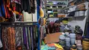 Seorang pedagang menata peci untuk dijual selama bulan suci Ramadan di dekat Masjid Sunan Ampel, Surabaya, Jawa Timur, pada Minggu 8 Maret 2026. Sepanjang Ramadan, kawasan sekitar Masjid Sunan Ampel, Surabaya, Jawa Timur, berubah menjadi pusat belanja dan kuliner yang kental dengan nuansa Timur Tengah. (JUNI KRISWANTO/AFP)