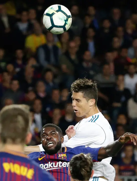 Pemain Real Madrid, Cristiano Ronaldo menyundul bola pada pertandingan La Liga Spanyol kontra Barcelona di Stadion Camp Nou, Minggu (6/5). Real Madrid yang bermain dengan 11 pemain gagal mengalahkan 10 pemain Barcelona. (AP/Emilio Morenatti)