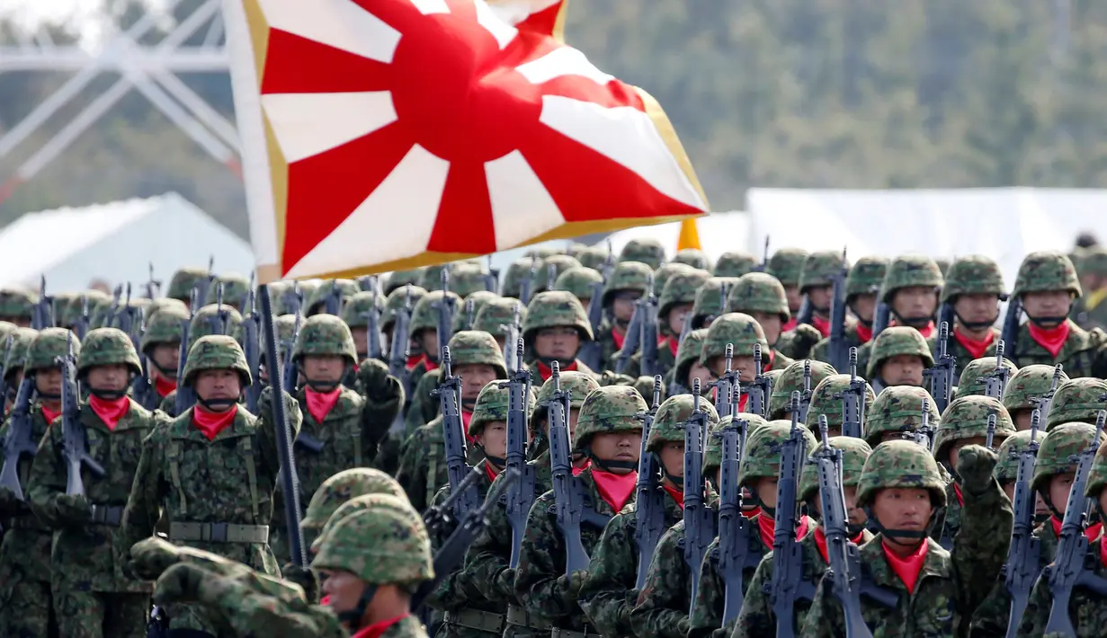 Pasukan bela diri Jepang unit infantri berbaris saat upacara tahunan Pasukan Bela Diri (SDF) di Pangkalan Asaka, Jepang(23/10). Upacara ini dihadiri oleh Perdana Menteri Jepang Shinzo Abe. (Reuters/Kim Kyun-Hoon)