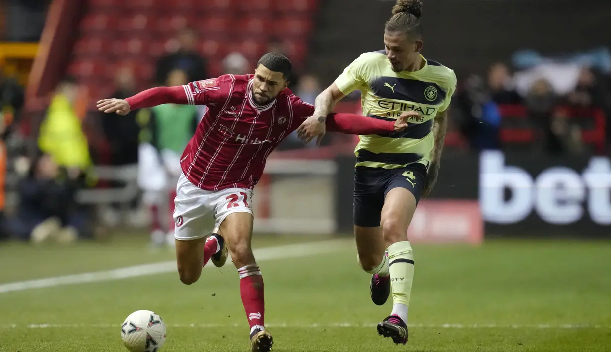 Gelandang Manchester City Kalvin Phillips berebut bola dengan penyerang Bristol City Nahki Wells pada putaran ke-5 Piala FA 2022/2023 di Ashton Gate Stadium, Rabu dini hari (1/3/2023). Man City memastikan kemenangan 3-0 untuk melaju ke perempat final Piala FA 2022-2023.  (AP Photo/Kirsty Wigglesworth)