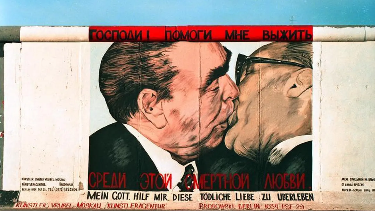 Mural Pemimpin Jerman Timur Erich Honecker berciuman dengan pemimpin Uni Soviet Leonid Brezhnev di Tembok Berlin pada masa Perang Dingin (Bundesarchiv/Joachim F Thurn via Wikimedia Commons)