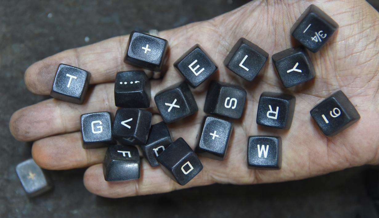 Pekerja menunjukan tombol mesin tik tua di bengkelnya di Mumbai, India (6/7). Walaupun dunia barat sudah meninggalkan, India membuktikan telah menjadi basis terakhir pertahanan penggunaan mesin ketik. (AFP Photo/Indranil Mukherjee)
