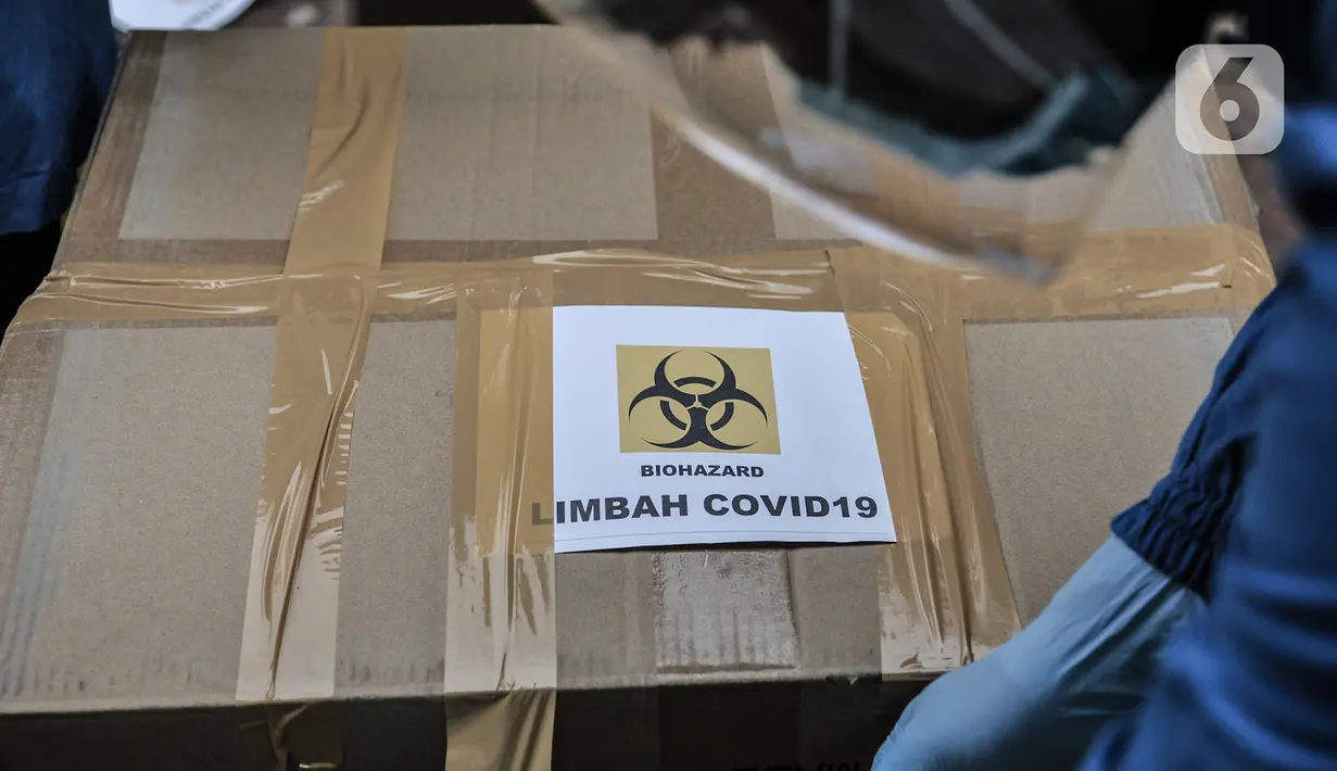 Petugas memasangkan label Covid-19 pada salah satu kardus di Tempat Penyimpanan Sementara Limbah B3 di Laboratorium Kesehatan Daerah (Labkesda) DKI Jakarta, Selasa (4/8/2020). Selama pandemi, jumlah limbah Covid-19 di Labkesda DKI mencapai 70 kilogram setiap harinya. (merdeka.com/Iqbal Nugroho)