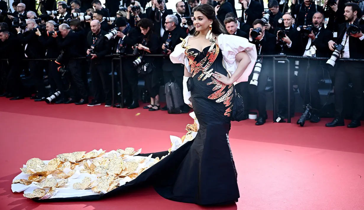 Gaun ini memiliki long rain dengan bunga-bunga emas yang besar dan tampak seperti sebuah perpanjangan dari tema Met Gala 'The Garden of Time'. (LOIC VENANCE / AFP)