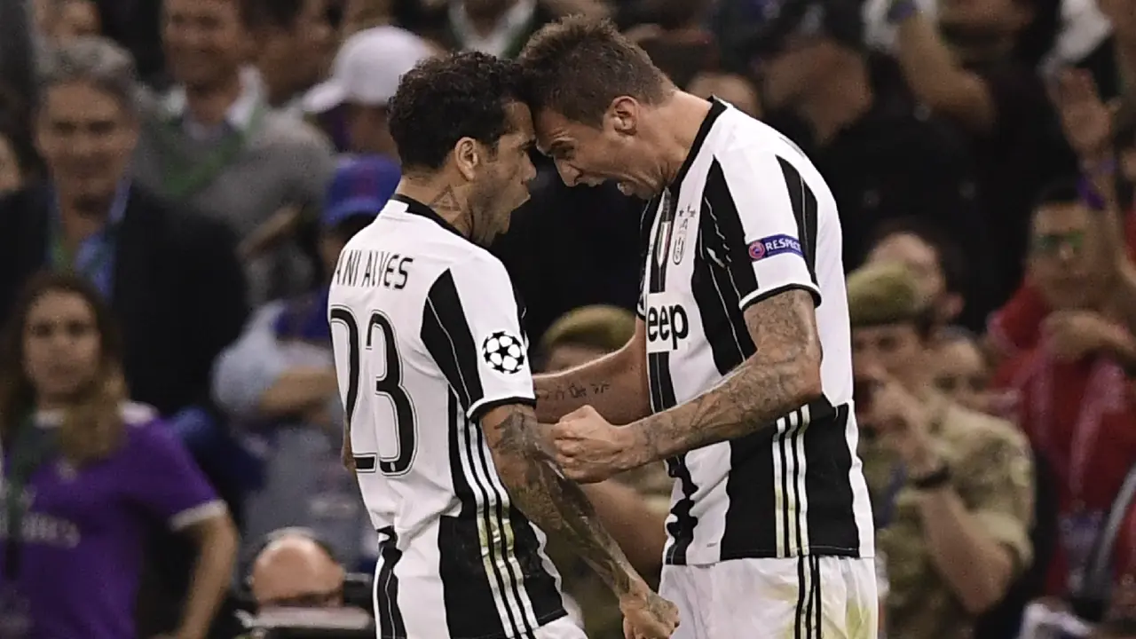 Penyerang Juventus, Mario Mandzukic (kanan), merayakan gol ke gawang Real Madrid pada final Liga Champions dengan Dani Alves, 3 Juni lalu. Mandzukic membantah Alves bertengkar dengan Leonardo Bonucci.