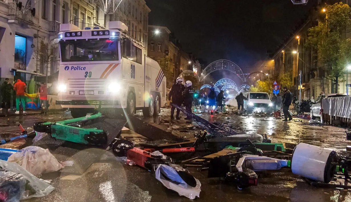 Polisi antihuru-hara berdiri di jalan utama di Brussel, Belgia, 27 November 2022. Polisi harus menutup sebagian pusat Kota Brussel dan bergerak dengan meriam air serta gas air mata untuk membubarkan massa menyusul kerusuhan selama dan setelah Maroko menang 2-0 atas Belgia di Piala Dunia 2022. (AP Photo/Geert Vanden Wijngaert)