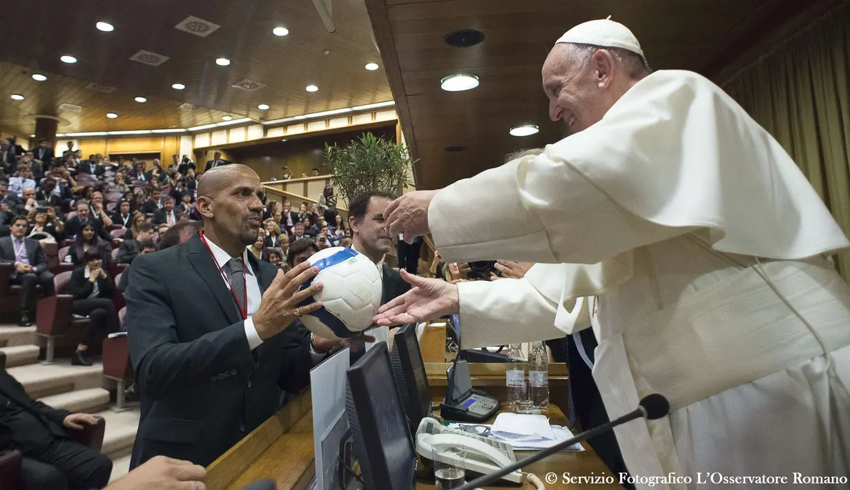 Mantan pesepak bola Argentina, Juan Sebastian Veron memberikan bola kepada Paus Fransiskus dalam pertemuan dengan para peserta Kongres Dunia Keenam Yayasan Kepausan Scholas Occurrentes, pada tanggal 29 Mei 2016 di Vatikan. Scholas adalah organisasi internasional hak kepausan yang disetujui dan dibentuk oleh Paus Fransiskus di Kota Vatikan pada tanggal 13 Agustus 2013. Organisasi ini menggabungkan teknologi dengan seni dan olahraga untuk mempromosikan integrasi sosial dan budaya perjumpaan demi perdamaian.  (AFP/Osservatore Romano)
