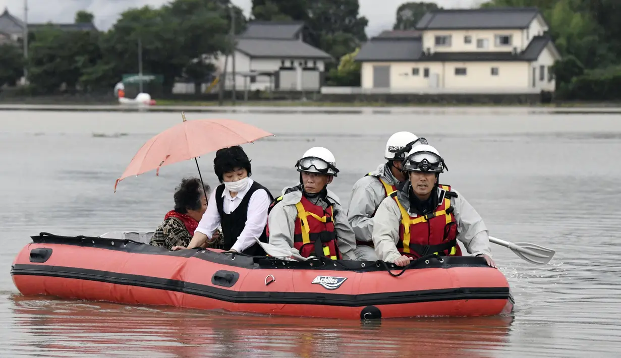 Warga dievakuasi menggunakan perahu karet saat banjir merendam daerah Asakura di prefektur Fukuoka, Kamis (6/7). Hujan lebat yang disebabkan angin topan di selatan Jepang telah memaksa evakuasi hampir 400.000 orang. (Sadayuki Goto/Kyodo News via AP)