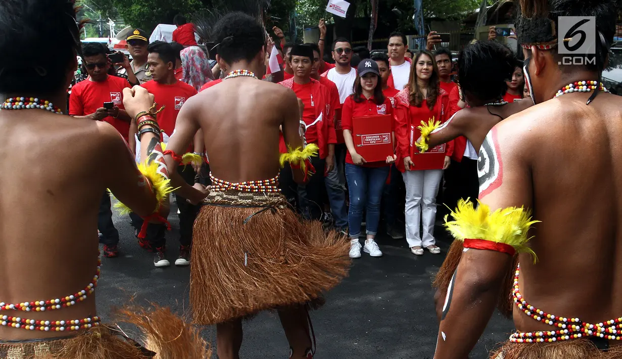 Tarian tradisional Papua mengiringi kedatangan kader Partai Solidaritas Indonesia (PSI) di kantor KPU, Selasa (10/10). Dipimpin sang ketua umum, Grace Natalie, PSI datang untuk mendaftarkan partainya sebagai peserta Pemilu 2019. (Liputan6.com/Johan Tallo)