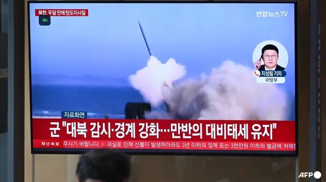 Siaran berita dengan rekaman uji coba rudal Korea Utara, di sebuah stasiun kereta api di Seoul, Korea Selatan pada 8 Mei 2025. (AFP/Jung Yeon-je)