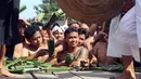 Sejumlah pria Bali menonton Perang Pandan di Bali (8/6). Perang Pandan merupakan salah satu tradisi yang dilakukan untuk menghormati dewa Indra atau Dewa perang. (AP/Firdia Lisnawati)