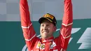 Pembalap Ferrari, Sebastian Vettel berpose dengan trofinya setelah memenangi balapan GP Australia di Sirkuit Albert Park, Melbourne, Minggu (26/3). Sebastian Vettel finis dengan catatan waktu tercepat 1 jam 24 menit 11,672 detik. (AP Photo/Rick Rycroft)