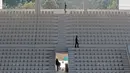 Pekerja merapikan kursi dan lantai Venue Aquatic Center di Senayan Sport Center, Jakarta (04/10/2017). Gedung dirancang semi terbuka. Atapnya tidak sepenuhnya menutupi bangunan, sehingga cahaya bisa masuk dengan leluasa. (Bola.com/Nicklas Hanoatubun)