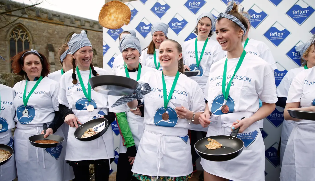 Kaia Larkas usai memenangkan lomba lari sembari membawa wajan berisi pancake di Kota Olney, Buckinghamshire, Inggris, Selasa (28/2). Lomba yang digelar pada Hari Pancake atau Pancake Day ini diadakan satu hari menjelang Rabu Abu. (AP Photo/Alastair Grant)