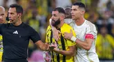 Pemain Al Nassr, Cristiano Ronaldo (kanan) mencoba meredam emosi dari pemain Ittihad FC, Karim Benzema pada laga lanjutan Liga Arab Saudi di King Abdullah Sports City, Jeddah, Arab Saudi, Sabtu (07/12/2024) dini hari WIB. (AFP)