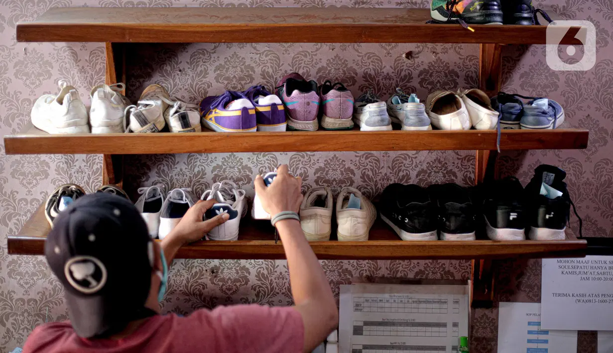 Kru mengambil sepatu untuk dibersihkan di Soul Sepatu di kawasan Rawamangun, Jakarta, Senin (9/11/2020). Jasa pencucian sepatu mengalami peningkatan permintaan pasca sebesar 50 persen pasca pemerintah menerapkan PSBB masa transisi di DKI Jakarta. (Liputan6.com/Faizal Fanani)