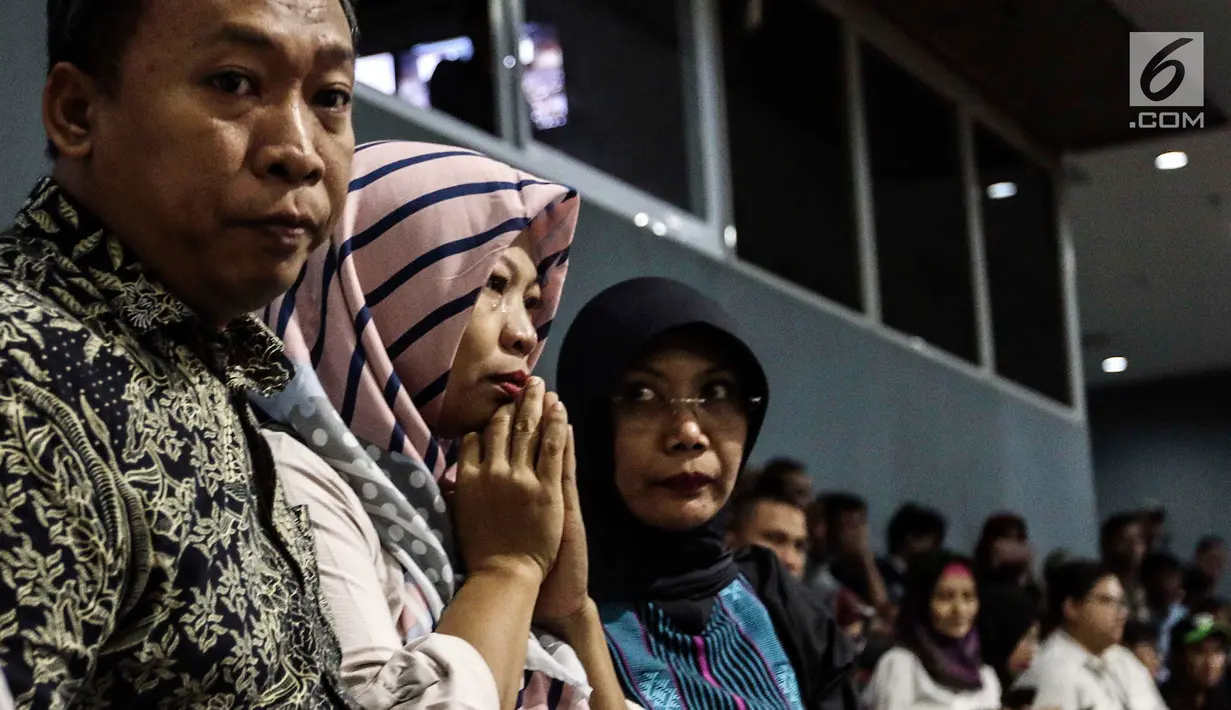 Ekspresi terpidana kasus dugaan pelanggaran UU ITE sekaligus korban pelecehan seksual Baiq Nuril saat menghadiri rapat paripurna DPR di Kompleks Parlemen Senayan, Jakarta, Kamis (25/7/2019). Baiq tak kuasa menahan tangis saat DPR mengesahkan persetujuan amnesti untuknya. (Liputan6.com/JohanTallo)