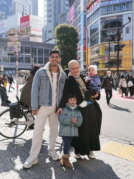 Kali ini, Dwi Handayani berfoto bersama keluarga kecilnya. Dwi Handayani tampak mengenakan sweater bermotif bunga ditumpuk long coat, dan pleated skirt hitam, menggendong sang buah hati yang mengenakan jaket biru dan celana hitam. Sedangkan suaminya mengenakan kaus putih polos, ditumpuk jacket jeans, dan celana putih. Anaknya yang lebih besar tampak mengenakan puffer jakcet abu-abu dengan legging biru navy. Foto: Instagram.