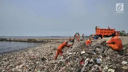 Petugas membersihkan sampah di pesisir Cilincing, Jakarta, Rabu (28/3). Menurut warga, hamparan sampah tersebut telah memenuhi pesisir Cilincing sejak puluhan tahun lalu hingga kini menjadi daratan yang dapat dilintasi. (Merdeka.com/Iqbal S. Nugroho)