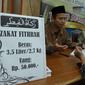 Petugas bersama seorang pria berdoa usai membayarkan zakat fitrah di Masjid Istiqlal, Jakarta, Jumat (23/6). Waktu pembayaran dibuka hingga malam takbiran dengan pembayaran zakat senilai Rp50ribu dan beras 3,5 liter. (Liputan6.com/Helmi Afandi)