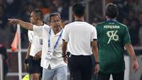 Ekspresi pelatih Persebaya Surabaya, Aji Santoso (kiri), saat melakukan protes kepada asisten wasit dalam pertandingan pekan kelima BRI Liga 1 2023/2024 melawan Persija Jakarta yang berlangsung di SUGBK, Jakarta, Minggu (31/7/2023). (Bola.com/Ikhwan Yanuar)