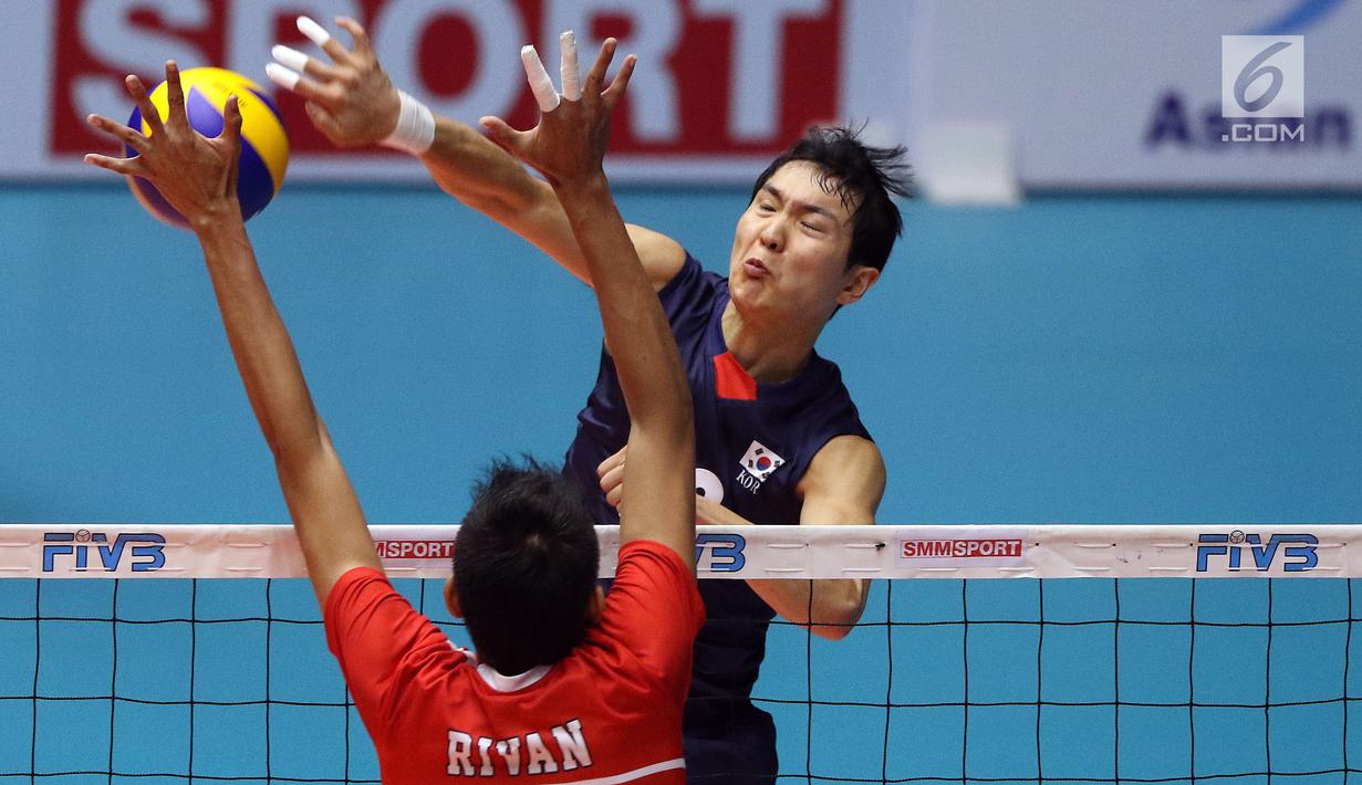 Pemain Timnas voli putra Indonesia, Rivan Nurmulki mencoba menahan smes pemain Korea Selatan pada babak 8 besar Grup E Kejuaraan Voli Asia 2017 di GOR Tri Dharma, Gresik, Kamis (27/7). Indonesia kalah 3-1. (Liputan6.com/Helmi Fithriansyah)