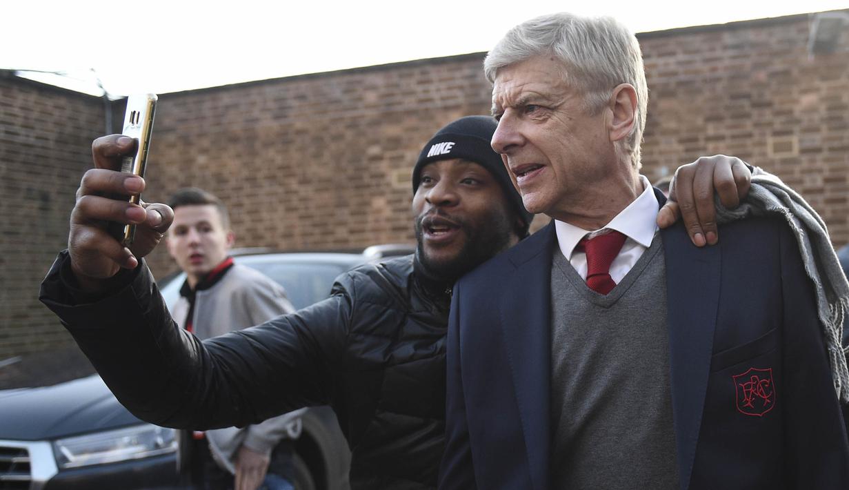 Pelatih Arsenal, Arsene Wenger, foto bersama fans sebelum laga Piala FA melawan Nottingham Forest di City Ground, Nottingham, Minggu (7/1/2018). (AFP/Oli Scarff)