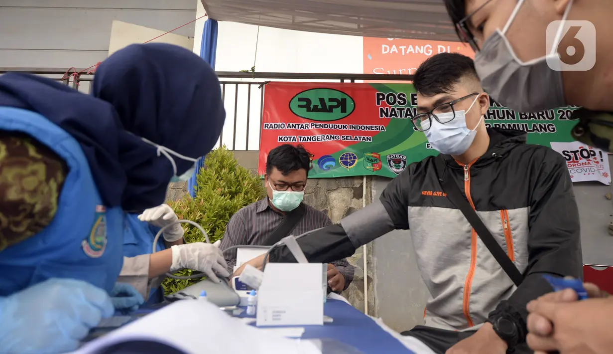 Petugas medis memeriksa kondisi warga saat rapid test di Pos PAM Pamulang Square, Tangerang Selatan, Banten, Jumat (25/12/2020). Rapid test gratis yang digelar Polres Tangerang Selatan tersebut bertujuan untuk mencegah penularan COVID-19 saat Natal dan Tahun Baru. (merdeka.com/Dwi Narwoko)
