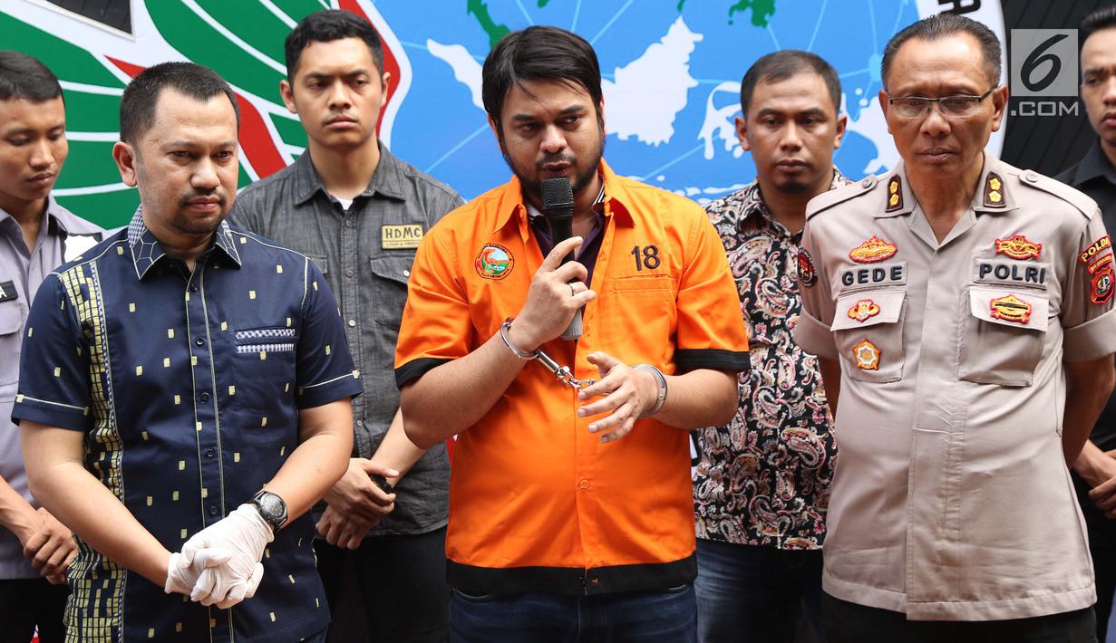 Pesinetron Rio Reifan (tengah) memberi keterangan bersama petugas Direktorat Reserse Narkoba Polda Metro Jaya saat rilis, Jakarta, Jumat (16/8/2019). Rio Reifan kembali ditahan polisi terkait kasus narkoba untuk kali ketiga. (Liputan6.com/Helmi Fithriansyah)
