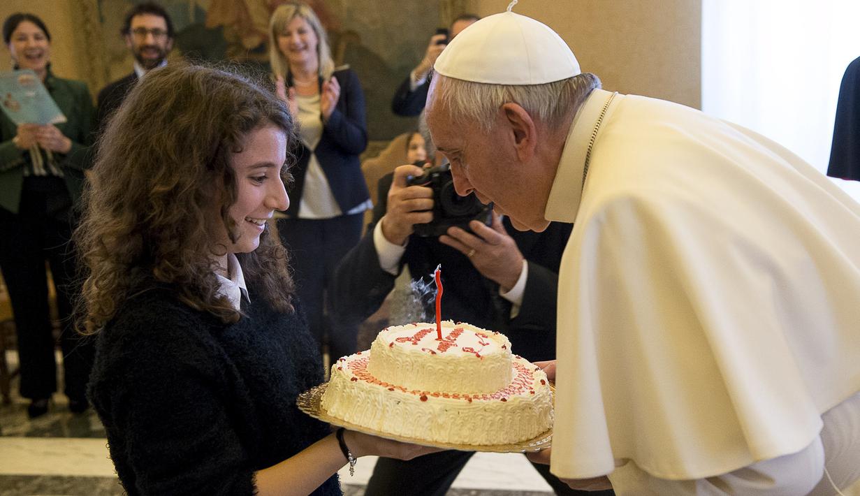 Paus Fransiskus meniup lilin kue ulang tahunnya yang diberikan oleh seorang anggota Italian Catholic Action saat ulang tahun ke-79 tahun di Vatikan, Kamis (17/12/2015). (REUTERS/Osservatore Romano)