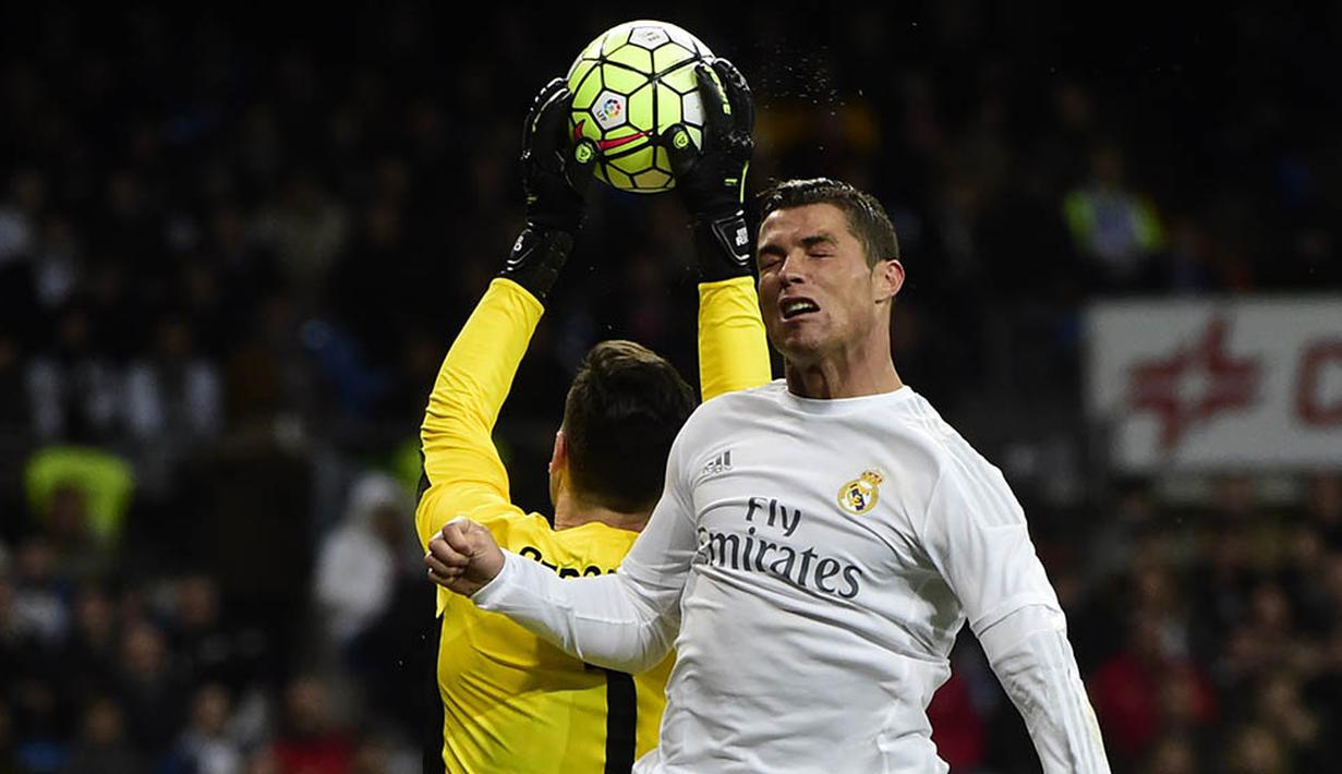 Penyerang Real Madrid, Cristiano Ronaldo, duel udara dengan kiper Sevilla, Sergio Rico, pada laga La Liga Spanyol di Stadion Santiago Bernabeu, Madrid, Minggu (20/3/2016). Madrid berhasil nanang 4-0 atas Sevilla. (AFP/Pierre-Philippe Marcou)