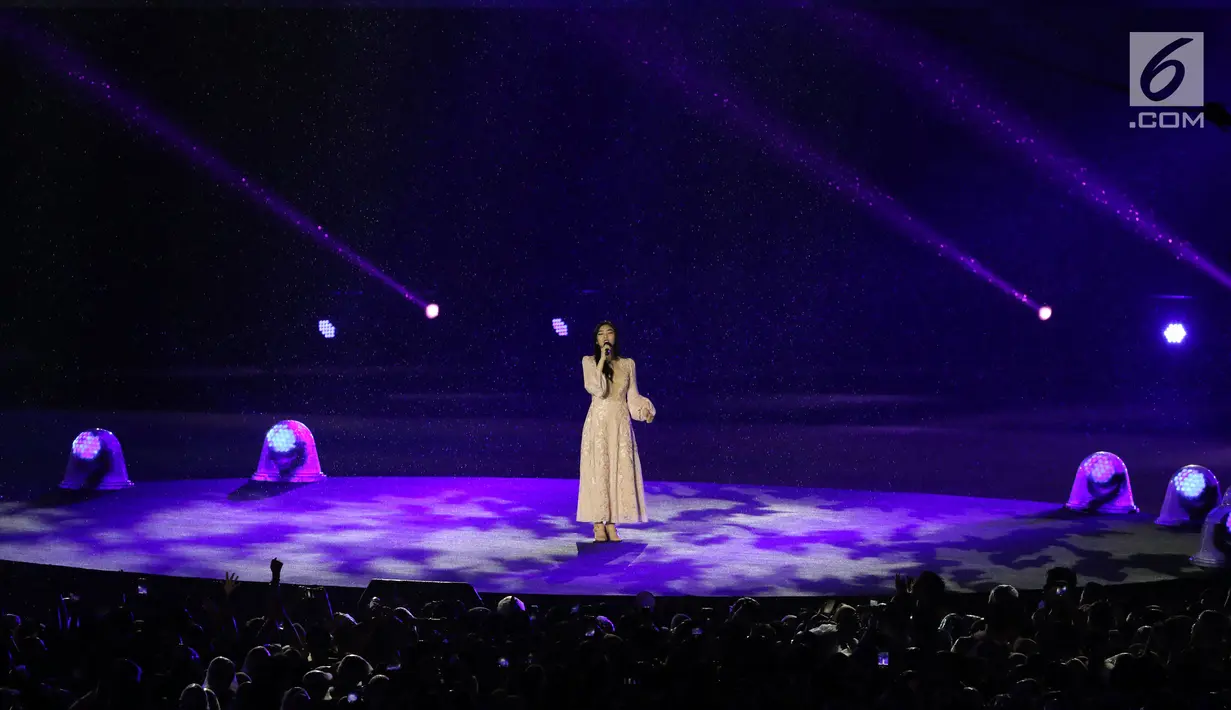 Penyanyi Isyana Sarasvati tampil dalam Upacara Penutupan Asian Games 2018 di Stadion Utama Gelora Bung Karno, Jakarta, Minggu (2/9). Vokalnya yang lembut mengalun saat mengiringi video cuplikan perjuangan para atlet. (Liputan6.com/Helmi Fithriansyah)
