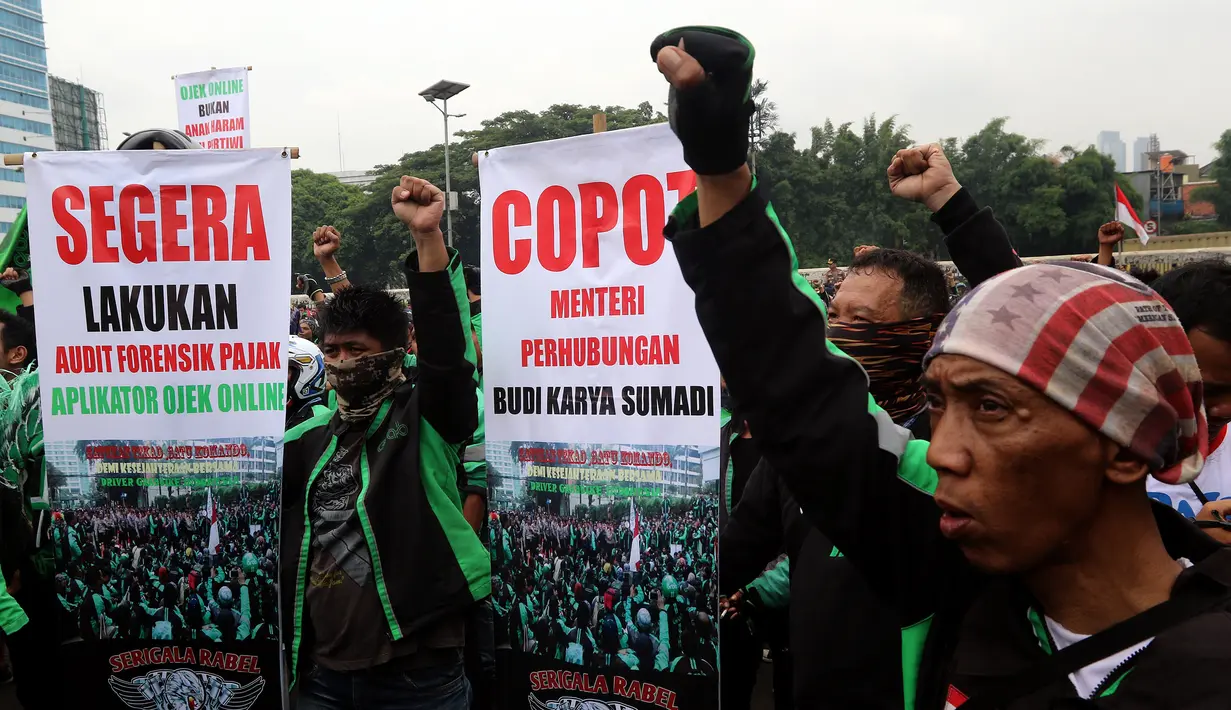 Pengemudi ojek online membentangkan spanduk aspirasi saat menggelar aksi unjuk rasa di depan Gedung MPR DPR, Jakarta, Senin (23/4). Dirlantas Polda Metro Jaya Kombes Yusuf mengimbau agar demonstran tertib. (Liputan6.com/Johan Tallo)